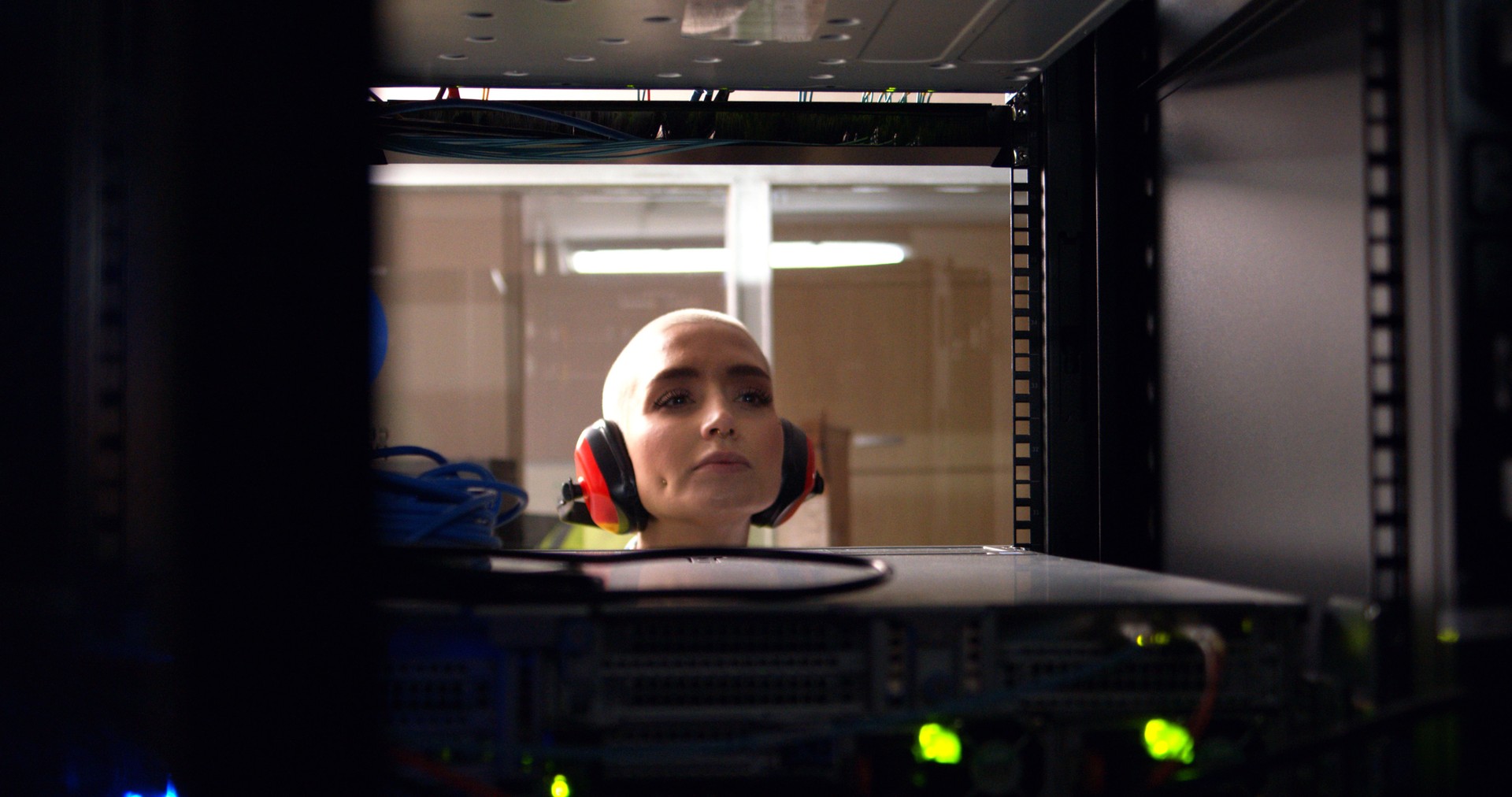 Computer engineer, working and database in server room for cyber security and troubleshooting a glitch in network. Woman, IT support and fixing dashboard equipment and earmuff for noise protection